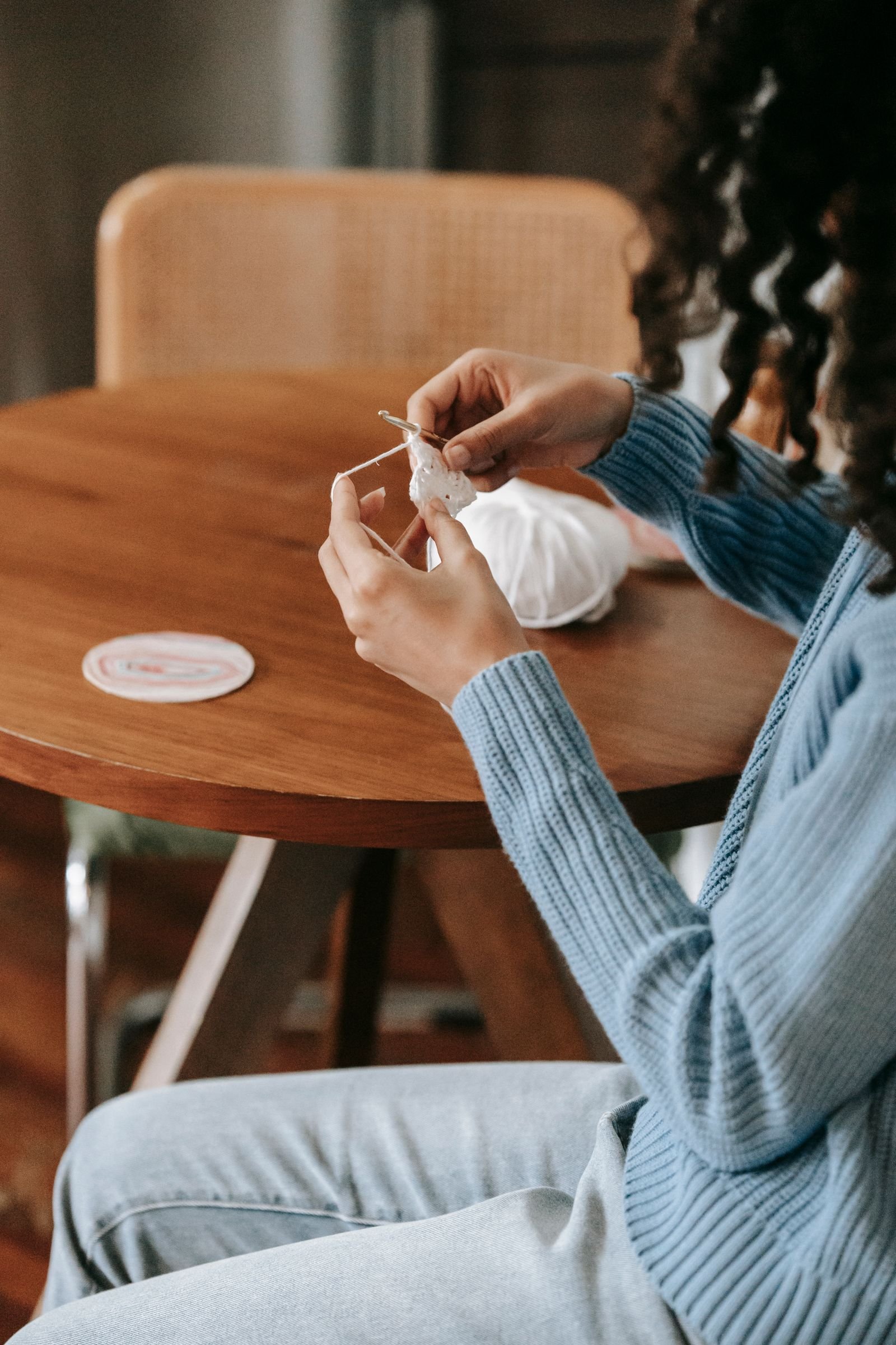 Woman crocheting at a wooden table